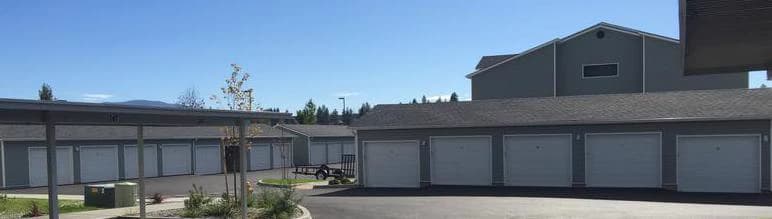 Detached garage building with a full row of insulated steel doors at a multi-family property